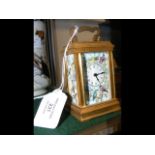 A miniature brass cased carriage clock with bird p