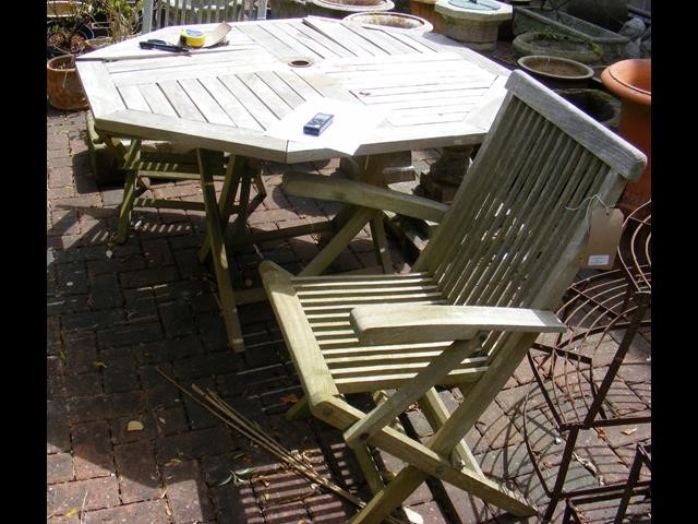 A garden table together with four folding chairs