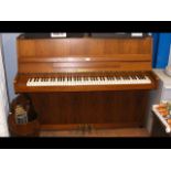 A Zimmerman upright piano in light wood cabinet -