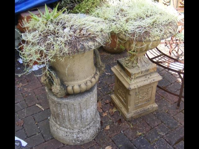 Two garden urns on plinths