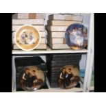 Two shelves of boxed special occasion plates, incl