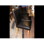 A set of four dining chairs with brown leather sea