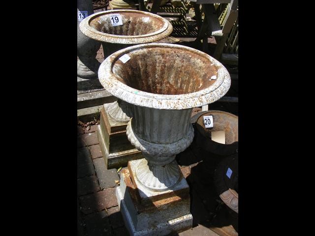 A pair of cast metal garden urns on plinths - 67cm