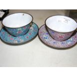A pair of antique enamel on metal cups and saucers