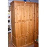 A pine linen press wardrobe with bi-fold doors and