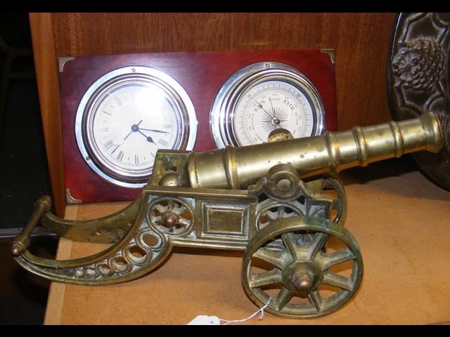 A brass canon together with a mounted clock and ba