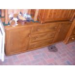An Ercol retro sideboard with 3 central drawers -