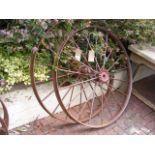 A large cast metal cart wheel and one other