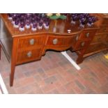 An Edwardian writing desk with five drawers to the