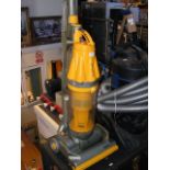A Dyson DC07 upright vacuum cleaner in yellow and