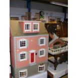 A Georgian style dolls house with basement, complete with extensive furnishings and front garden