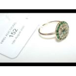 An emerald and diamond ring in gold setting