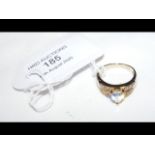 An 18ct gold pear shaped white sapphire ring surro