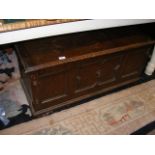 An oak blanket box with panelled front