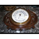 A small wall barometer in oak case