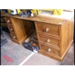 A pine desk with six drawers to the front