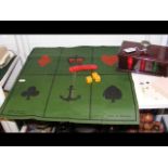 An antique sailor's gambling game, Crown & Anchor, consisting of green canvas board and dice, togeth