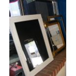 A bevelled wall mirror in black and gilt frame tog