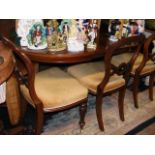 An extending reproduction mahogany dining table with a set of four Victorian style chairs