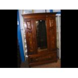 An antique mirrored wardrobe with drawer below