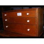 A three drawer miniature cabinet containing shells