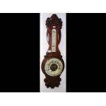 An antique wall barometer/thermometer