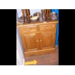 A pine side cabinet with drawers and cupboards und