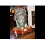 A bronze deity head on wooden stand - 31cm high