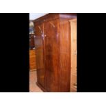 A Victorian mahogany wardrobe enclosed by a pair o