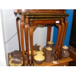 A nest of three walnut occasional tables with cabr