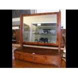 An antique toilet mirror with three drawers to the