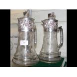 A pair of silver plated claret jugs with grape and