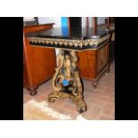 A gilt and black painted centre table on tripod ba