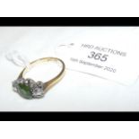 An 18ct gold diamond and green stone ring