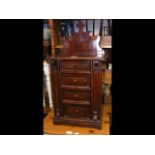 A gothic mahogany miniature four drawer cabinet -