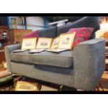 A two seater settee upholstered in charcoal, with