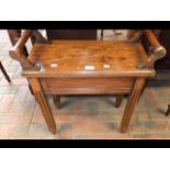 A wooden stool with reeded supports