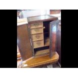 An antique smoker's cabinet with two doors to the