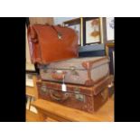 A vintage leather suitcase, another suitcase toget