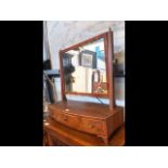 An antique toilet mirror with three drawers to the