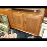 An Ercol Golden Dawn sideboard with three cupboards single drawer