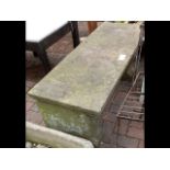 A rectangular stone garden bench
