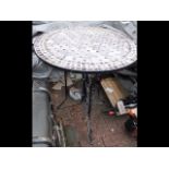 A circular wrought iron garden table