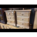 A pair of pine bedside three drawer chests