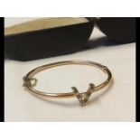 A ladies elegant yellow metal bangle with diamond