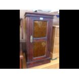 An antique pot cupboard with glass panelled door