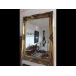A decorative gilt framed wall mirror - 92cm x 66cm