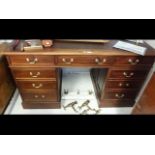A mahogany pedestal desk , brown leather top and n