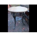 A circular cast iron and wooden pub table