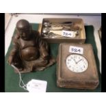A bronze buddha, silver cased travelling clock etc